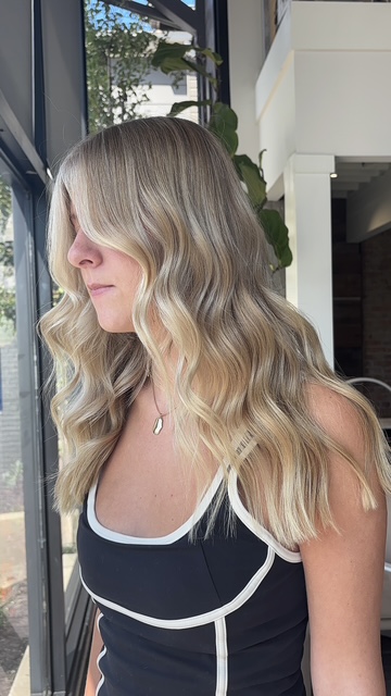 Blonde balayage with soft waves, side view, by Evelyn